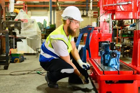 Mechanical engineer repairing engine machine at factory Stock Photos