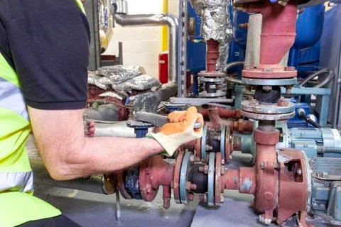 Mechanical engineer in safety vest working on a pump set Stock Photos