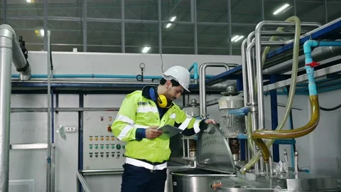 Mechanical engineer with tablet checking condition of storage tank and pipeli Stock Footage 183829154