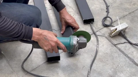 Mechanical engineer using hacksaw to cut metal frame to build the roof Stock Footage 152821998