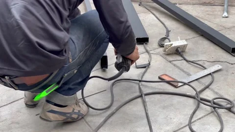 Mechanical engineer using hacksaw to cut metal frame to build the roof Stock Footage 152822000