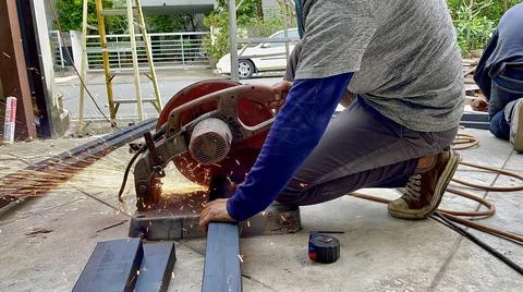 Mechanical engineer using hacksaw to cut metal frame to build the roof Stock Photos