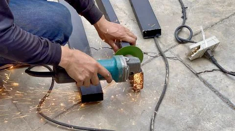 Mechanical engineer using hacksaw to cut metal frame to build the roof Stock Photos