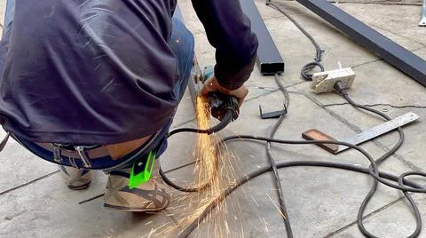 Mechanical engineer using hacksaw to cut metal frame to build the roof Stock Photos