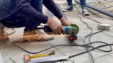 Mechanical engineer using hacksaw to cut metal frame to build the roof Stock Photos