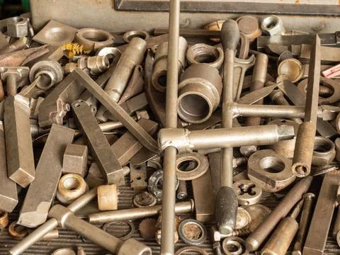 Mechanical engineering workshop workbench piled with various industrial steel Stock Photos