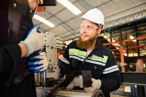 Mechanical engineers repairing engine machine at factory Stock Photos