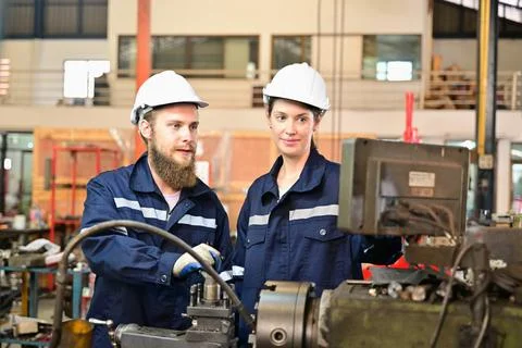 Mechanical engineers repairing engine machine at factory Stock Photos