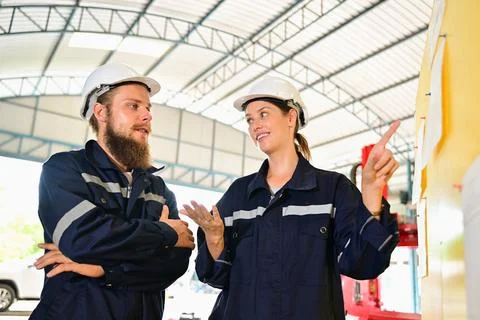 Mechanical engineers repairing engine machine at factory Foto stock