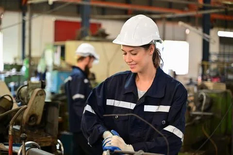 Mechanical engineers repairing engine machine at factory Stock Photos