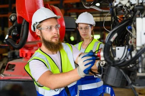 Mechanical engineers repairing engine machine at factory Foto stock