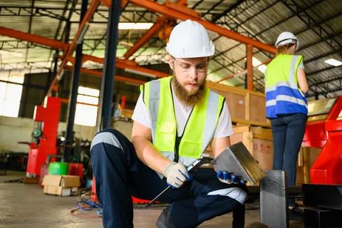 Mechanical engineers repairing engine machine at factory Stock Photos