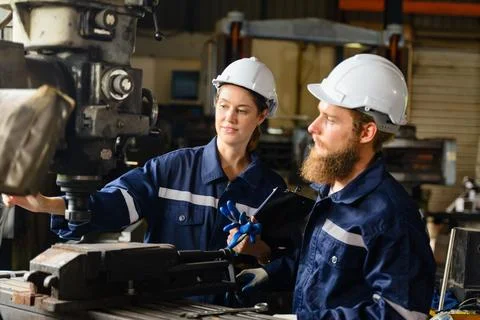 Mechanical engineers repairing engine machine at factory Stock Photos