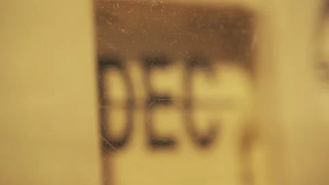 A mechanical flip clock changing a month name behind an old plastic case Stock Footage 284805296