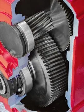 Mechanical gears inside a red engine casing. The gears are connected and posi Foto stock