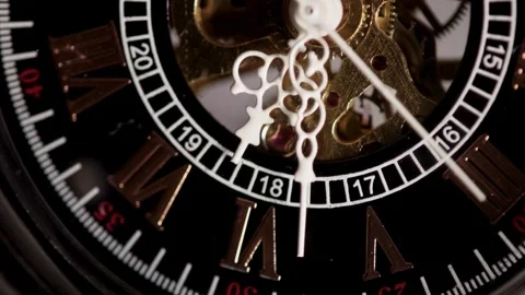 Mechanical gears moving behind black watch face with hands Stock Footage 329595740