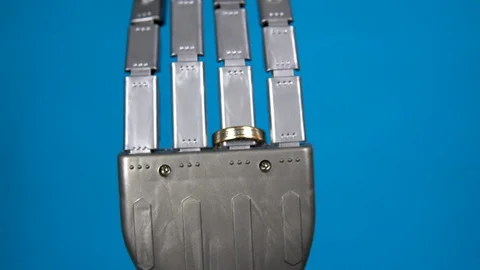A mechanical hand with a ring on the ring finger. Gray cyborg hand on a blue 스톡 동영상 126664961