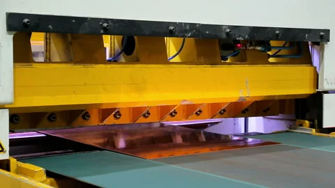 A mechanical knife cuts the ribbon of sheet copper into pieces Stock Footage 103847110
