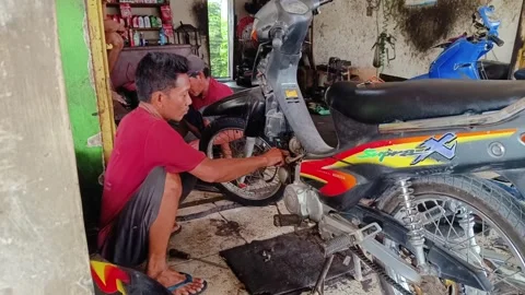 Mechanical man repairing a motorcycle engine Stock Footage 293459424