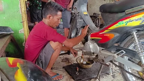 Mechanical man repairing a motorcycle engine Stock Footage 293460217