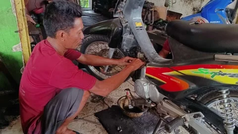 Mechanical man repairing a motorcycle engine Stock Footage 293460239