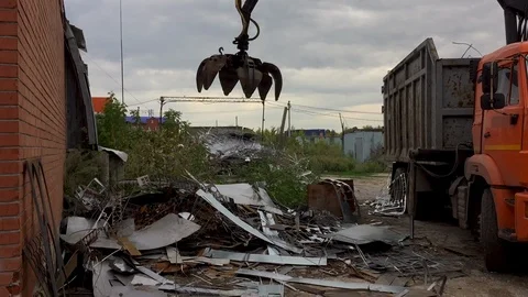 The mechanical manipulating grab, loads scrap metal into the garbage truck for Stockbeeldmateriaal 113975114