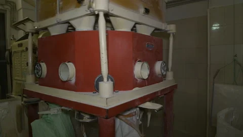 A mechanical mill that grinds whole grain wheat at a small mill industry Stock Footage 173477425