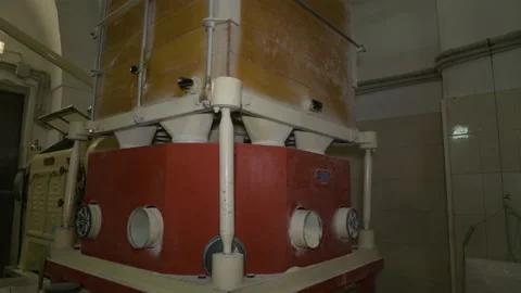 A mechanical mill that grinds whole grain wheat at a small mill industry Stock Footage 173480786