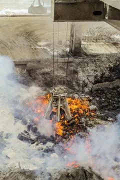 Mechanical multivalve clamshell grapple with red-hot pieces of iron Stock Photos