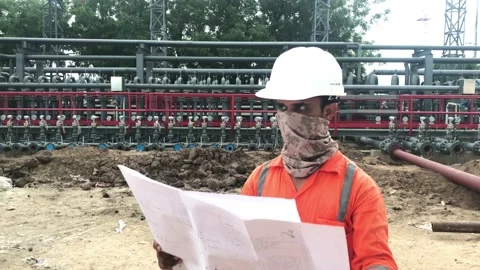 Mechanical site engineer reading drawing wear face protection mask. Stock Footage 159792731