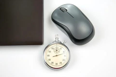 Mechanical stopwatch on a background of a computer mouse and laptop on a wh.. Stock Photos
