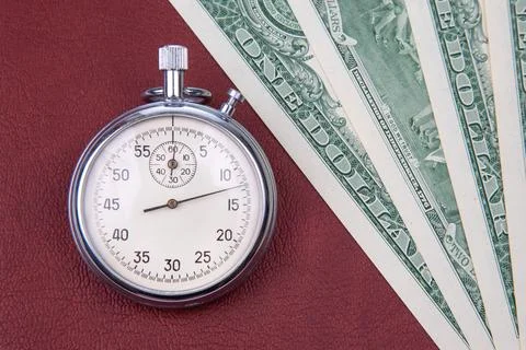 Mechanical stopwatch on the background of dollars. Part time accuracy for b.. Stock Photos