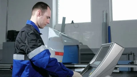 Mechanical technician programming punching the machine CNC. A man enters the Video stock 71644250