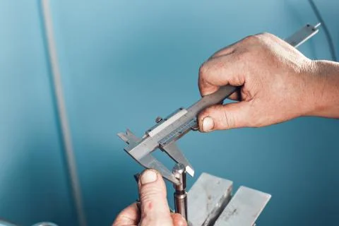 Mechanical technician worker hands measuring detail tool after processing at Stockfoto's
