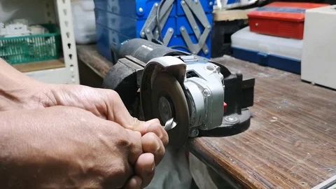 A mechanical worker sharpens the drill bit using a grinder manually. Stock Footage 121489526