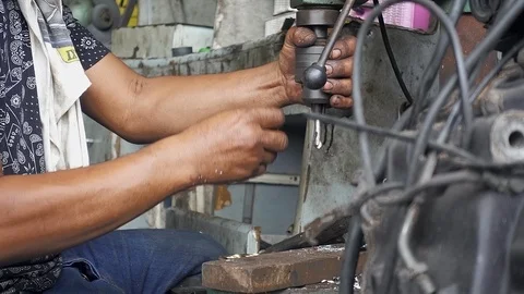 Mechanician setup and use drill machine to drill out some metal part of vehicle. Stock Footage 99999310