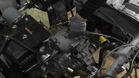 Mechanics in a car workshop disassemble the gearbox in the engine of a tricycle Stock Footage 156384875