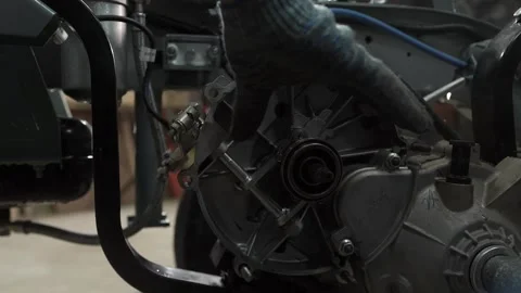 Mechanics in a car workshop disassemble the gearbox in the engine of a tricycle Stock Footage 156384929