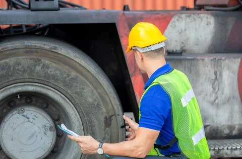 Mechanics checking wheel in cargo container. Professional technician pre-chec Фото