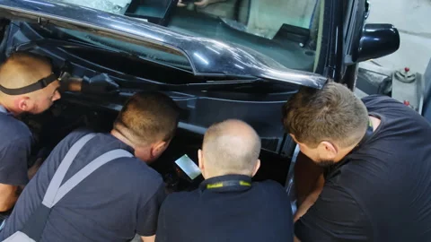 Mechanics conduct diagnostics with device under car bonnet Video stock 324709523