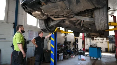 Mechanics doing technical inspection and diagnostic of vehicle at garage Stock-Footage 298172516