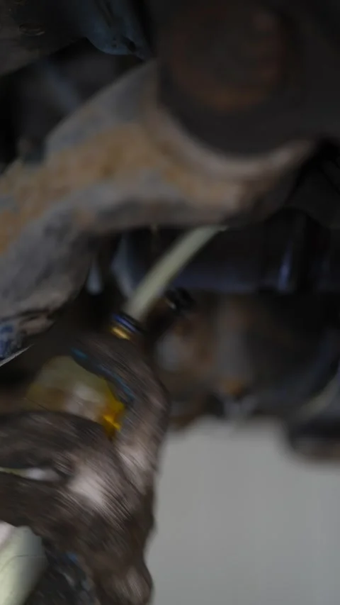 A mechanic's gloved hand holding a flexible plastic Stock Footage 343551824