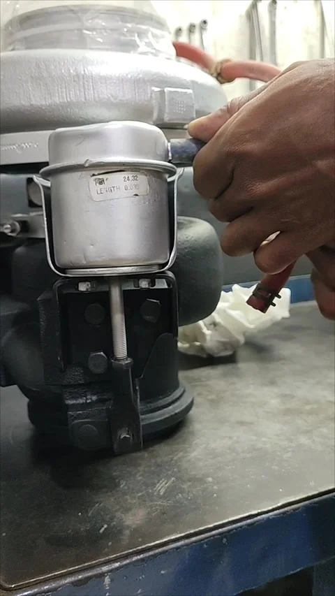 Mechanic's hand measuring and ensuring turbocharger actuator Stock Footage 304178476