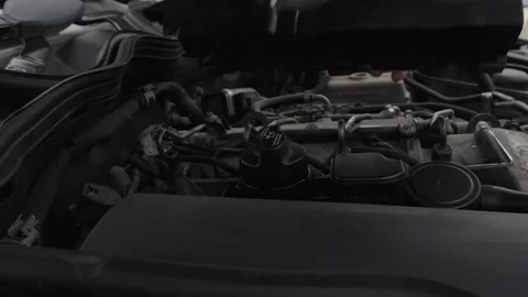 Mechanic's hand removes engine cover from car engine, revealing components and Stock Footage 328294011