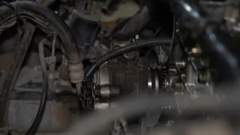 A mechanic's hand wearing a dirty work glove carefully installs or removes a  Stock Footage 345108803