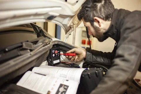 Mechanic's hands adjust the hydrogen system control unit in the car engine Foto stock