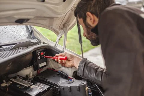 Mechanic's hands adjust the hydrogen system control unit in the car engine Stock Photos