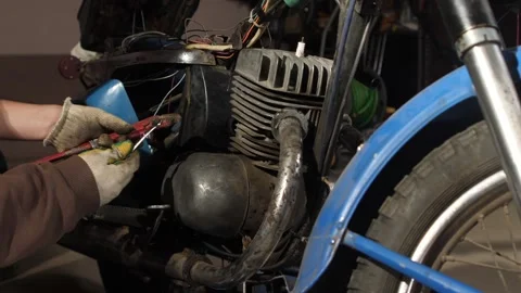Mechanic's hands in dirty work gloves using a red pipe wrench to perform Stock Footage 342764203