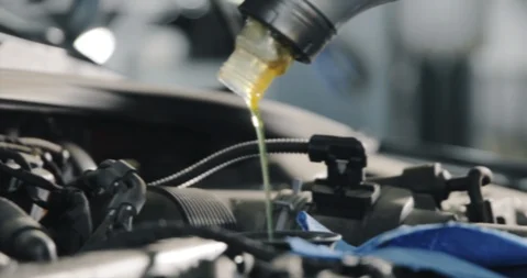 Mechanic's Hands. Engine Oil Flows From The Canister Into The Engine Of A Car. Video stock 124979830