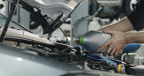 Mechanic's Hands. Engine Oil Flows From The Canister Into The Engine Of A Car. Video stock 124980049